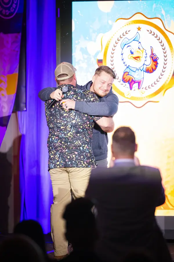 Two teammates hugging on stage at the awards