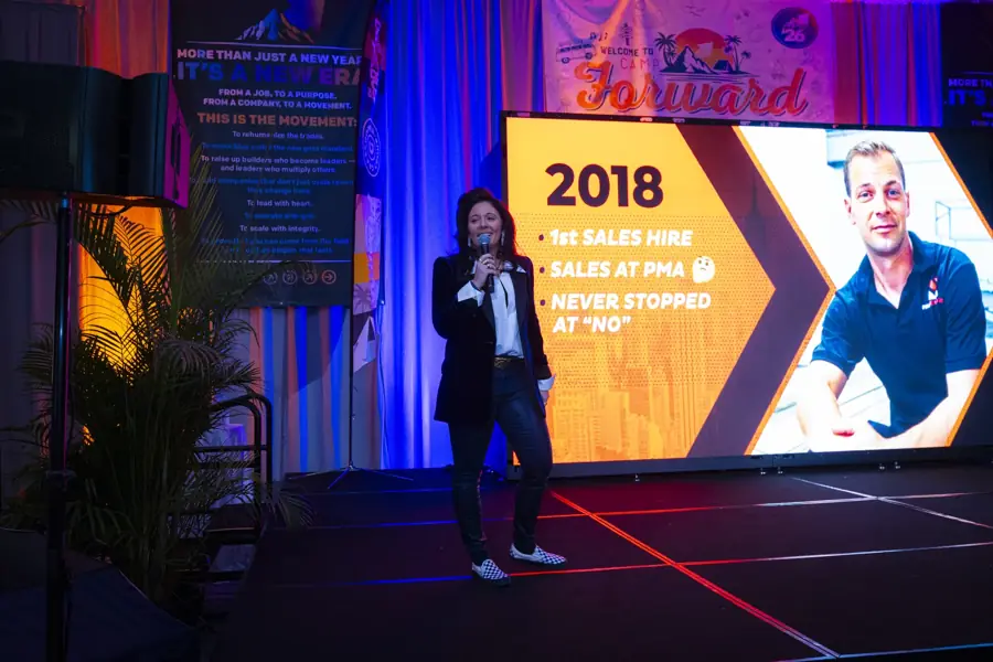 Amanda on stage at Camp Forward '26, telling the 2018 chapter
